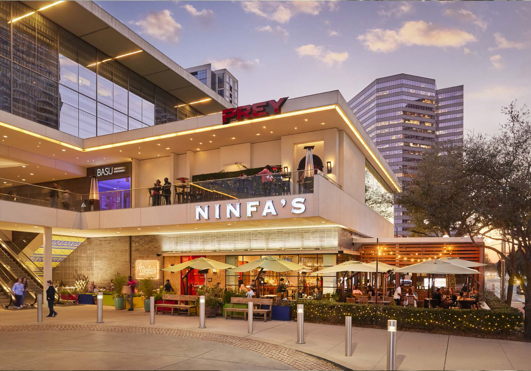 Outdoor view of Ninfa's Uptown with patio seating, modern buildings, and people at sunset.