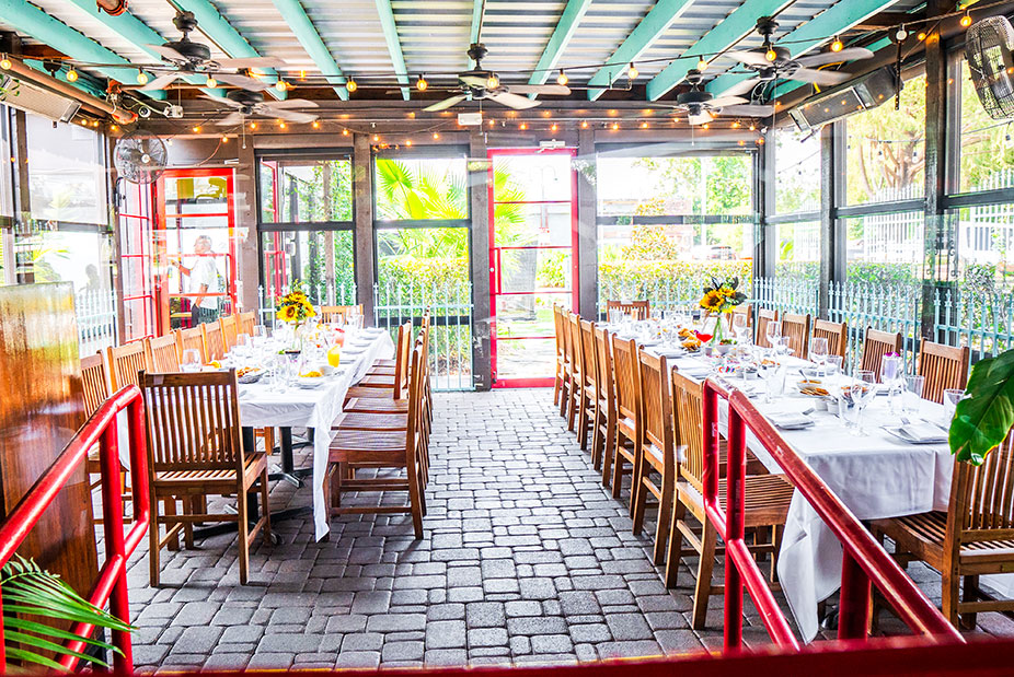 Bright, airy Garden Patio at Ninfa's on Navigation with long tables, wooden chairs, white tablecloths, and sunflower centerpieces.